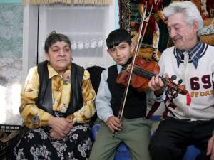 Străbunicii Tereza si Mihai, alături de Loris, acum 6 ani, când a primit în dar o vioară