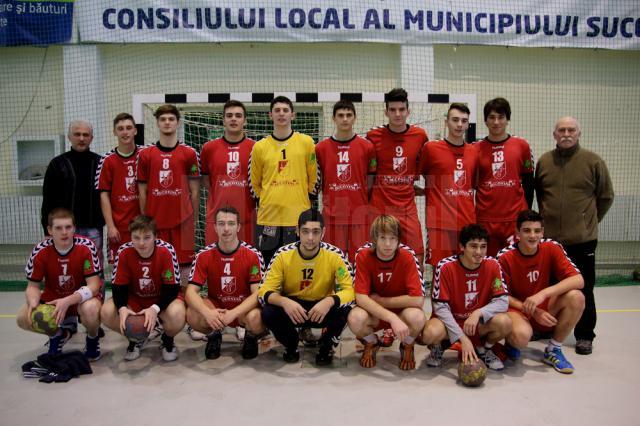 Jucătorii echipei de handbal juniori I a LPS Suceava, alături de antrenorii Iulian Dugan (stânga) și Petru Brândușe (dreapta)