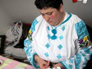 Elena Iurciuc, din Şerbăuţi, împodobeşte cămăşile tradiţionale cu mii de mărgele colorate
