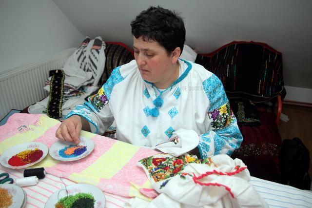 Elena Iurciuc, din Şerbăuţi, împodobeşte cămăşile tradiţionale cu mii de mărgele colorate