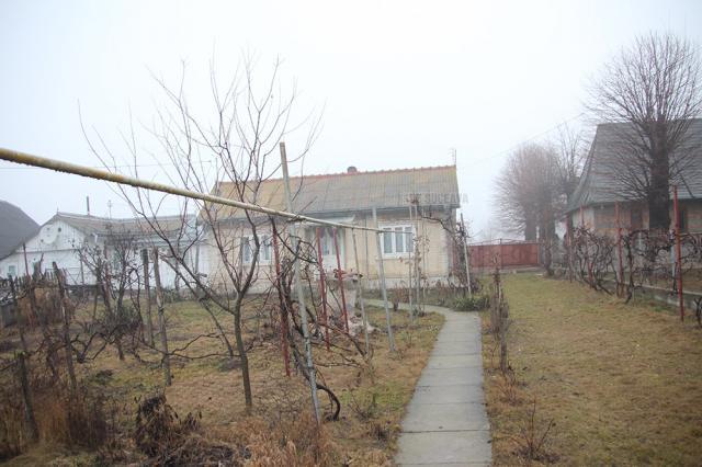 Casa bătrânei e chiar la marginea DN 29 Suceava-Botosani, gard în gard cu biserica din Plopeni