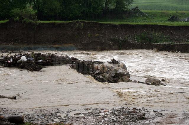 Podeţul din tuburi de beton a fost măturat de apele învolburate încărcate de gunoaie