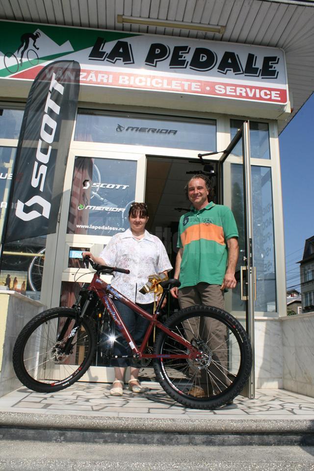 Câştigătoarea concursului şi-a primit bicicleta din mâna administratorului magazinului La Pedale, Tiberiu Serdenciuc