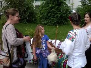 Turista din SUA îşi fotografiază fiica alături de obiecte tradiţionale din satele bucovinene