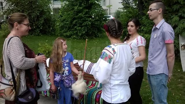 Turista din SUA îşi fotografiază fiica alături de obiecte tradiţionale din satele bucovinene