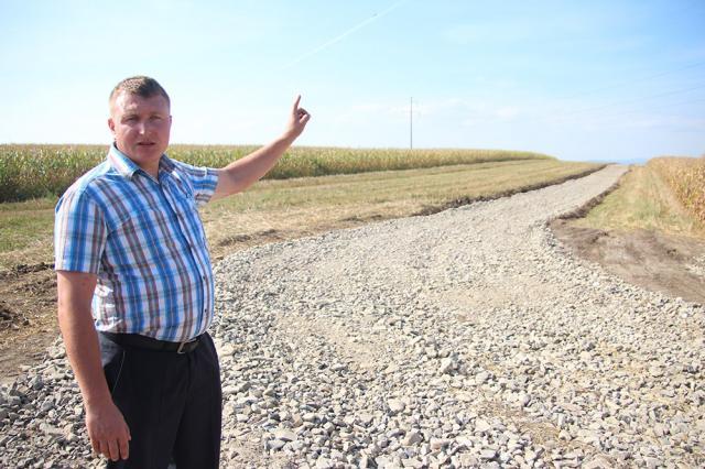 Primarul Mihai Senic, arătând drumul amenajat pentru ca maşinile cu gunoi să nu mai treacă prin sat