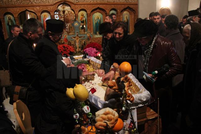 Familia îndurerată împreună cu un sobor de preoţi