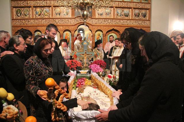 Familia îndurerată împreună cu un sobor de preoţi