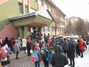 Copiii aşteaptă permisiunea de a intra în şcoală