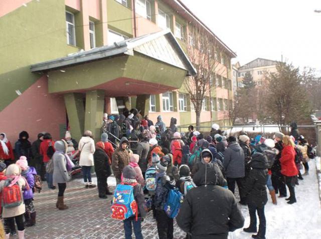 Copiii aşteaptă permisiunea de a intra în şcoală