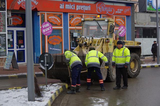 Trei echipe ale Diasil adună mormane de pietriş, nisip şi pământ din rigolele stradale