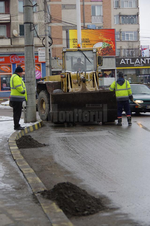 Trei echipe ale Diasil adună mormane de pietriş, nisip şi pământ din rigolele stradale