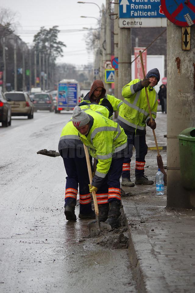 Trei echipe ale Diasil adună mormane de pietriş, nisip şi pământ din rigolele stradale