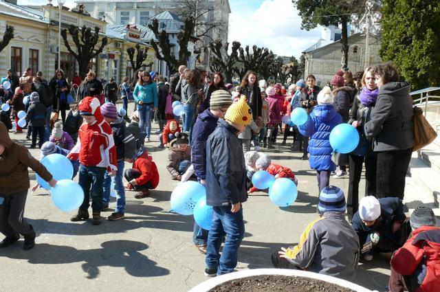 35 de copii însoţiți de cadre didactice şi voluntari de la Colegiul „Vasile Lovinescu” şi Şcoala Gimnazială „Ion Irimescu” s-au jucat cu preşcolarii de la Grădiniţa cu Program Prelungit „Pinocchio” cu baloane albastre