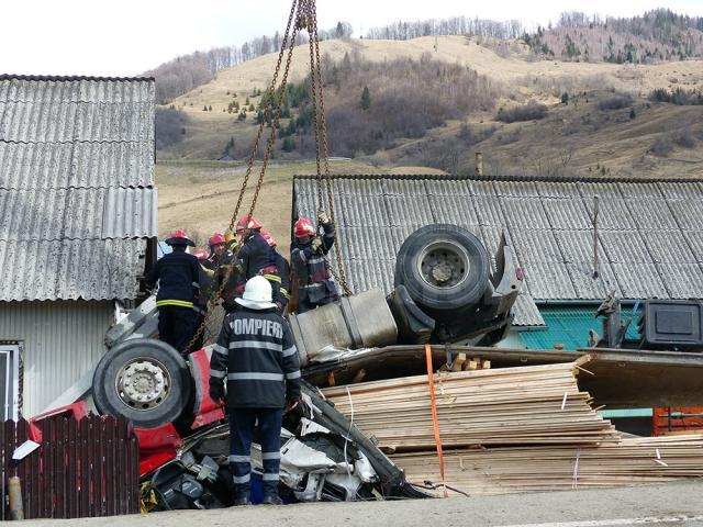 Maşina transformată într-un morman de fiare a fost ridicată cu mare greutate de pompieri, cu ajutorul unei macarale