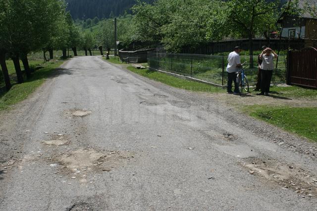 Drum asfaltat cu fonduri europene, reparat în bătaie de joc cu pământ şi piatră