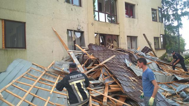 Acoperişul internatului unui liceu, aruncat de o tornadă la aproape 100 de metri, într-un bloc de locuinţe