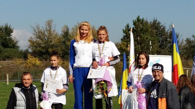 Atleta Andreea Doroftei, alături de antrenoarea Erzilia Țâmpău pe podiumul naționalelor de cros 1