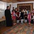 Copiii cântă împreună cu părintele şi preoteasa Mioara cântece pentru Moş Nicolae