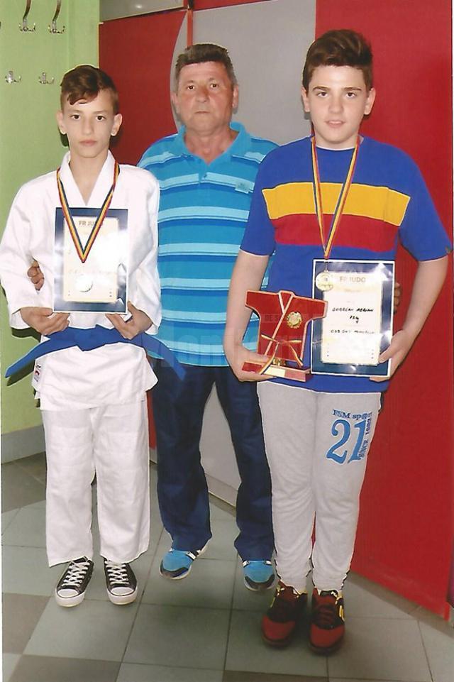 Antrenorul Mihai Pascal alături de doi dintre sportivii săi