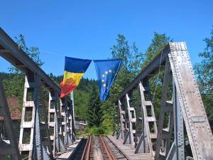 Pe podul metalic aflat chiar în Dornişoara, flutură ironic două steaguri: al României şi al Uniunii Europene