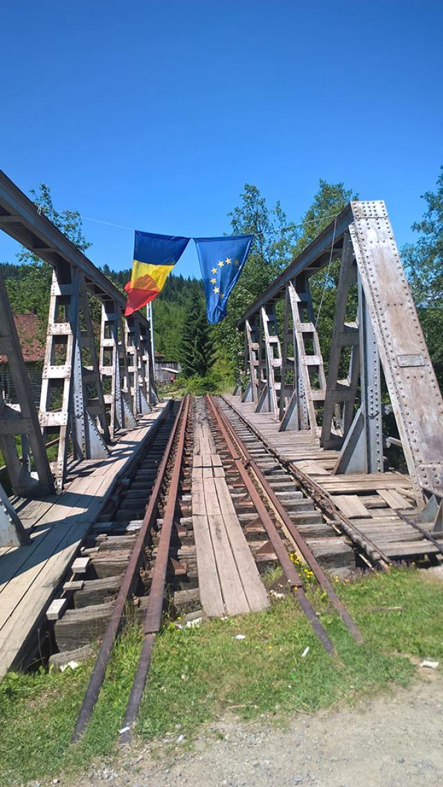 Pe podul metalic aflat chiar în Dornişoara, flutură ironic două steaguri: al României şi al Uniunii Europene