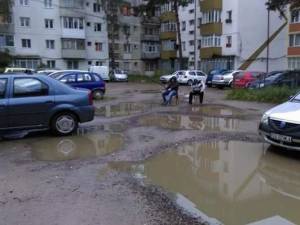 Parcarea dintre blocurile de pe str. Zorilor, unde doi tineri pescuiau în bălţile apărute după o ploaie torenţială