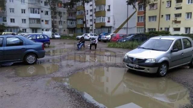 Parcarea dintre blocurile de pe str. Zorilor, unde doi tineri pescuiau în bălţile apărute după o ploaie torenţială
