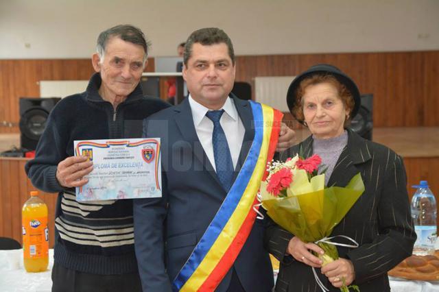 Primarul comunei Udești, Ostrovan Cristea, împreună cu o familie care a împlinit 50 de ani de căsătorie