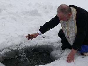 Preotul Domițian Tătaru sfințind apa râului Dorna