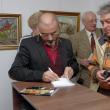 Tiberiu Cosovan dând autografe pe al patrulea volum din cartea „Efigii în filigran”