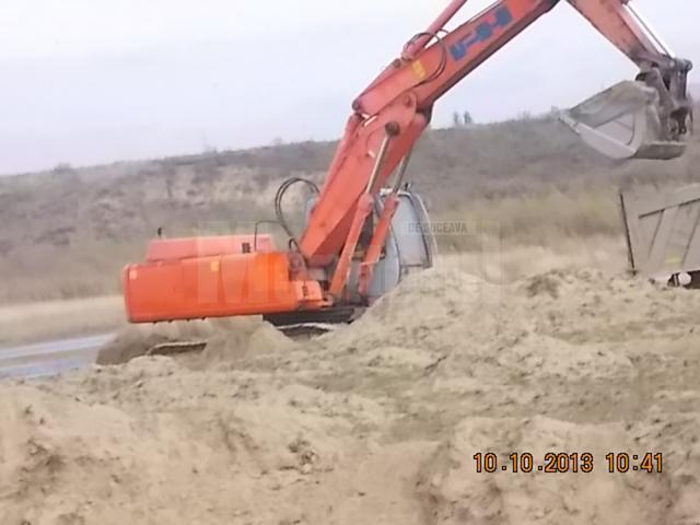 Excavatorul firmei, surprins în timp ce săpa pe malul râului Siret