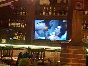 Pe ecranul televizorului situat deasupra barului au rulat scene porno, dintr-un film pentru adulţi