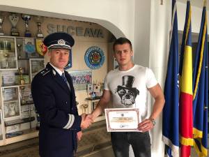 Tânărul poliţist, alături de comisarul Marius Ciotău, preşedintele CNP