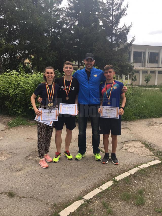 Antrenorul Iustin Tătărău alături de cei trei sportivi medaliaţi la naţionalele şcolare