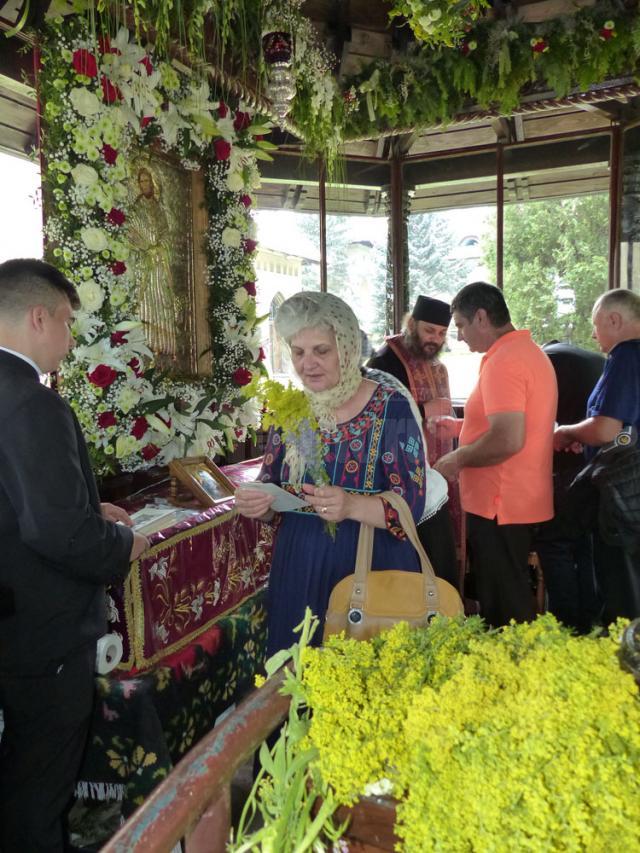 Cei care au ajuns la racla Sfântului, primesc flori de sânziene, un simbol al marii sărbători de la Suceava