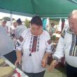 Primarul Gheorghe Fron invită oaspeţii să guste turta cu julfă
