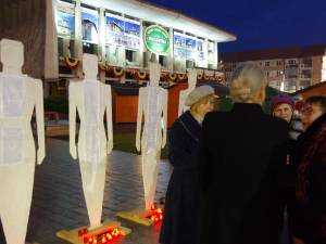 Zeci de lumânări aprinse la picioarele unor fragile siluete umane – simbolul femeilor dispărute, victime ale violenței domestice