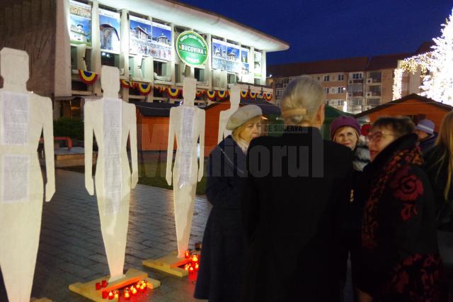Zeci de lumânări aprinse la picioarele unor fragile siluete umane – simbolul femeilor dispărute, victime ale violenței domestice