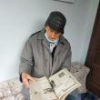 Sevastian Bogus răsfoind o colecție de ziare mai vechi