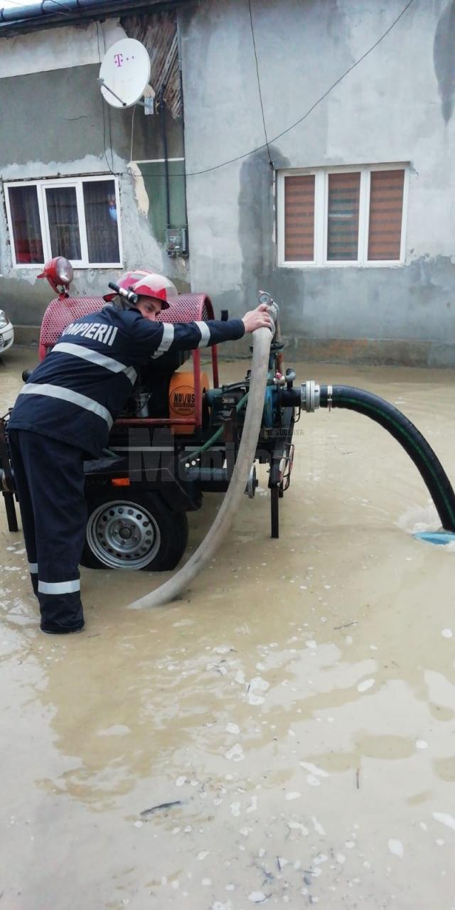 Pompierii actioneaza cu motopompe pentru evacuarea apei de pe drumuri si din curti
