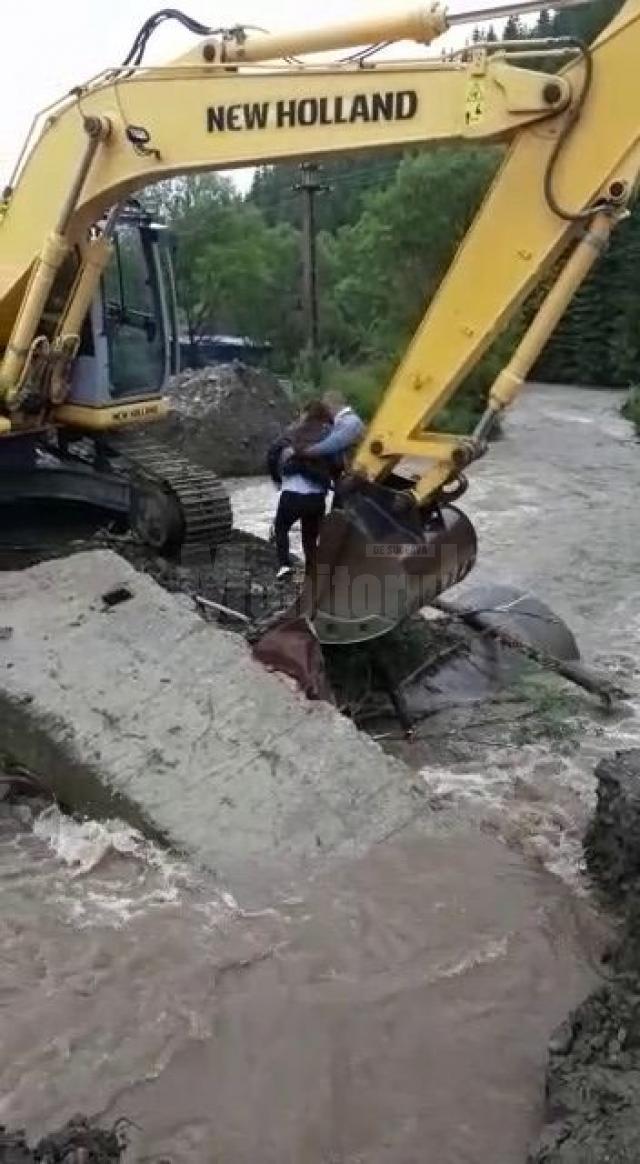 Adolescentă trecută în cupa excavatorului peste râul Brodina pentru a putea fi preluată de ambulanță