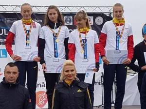 Antrenoarea Erzilia Țîmpău alături de sportivele sale, urcate pe cea mai înaltă treaptă a podiumului de premiere