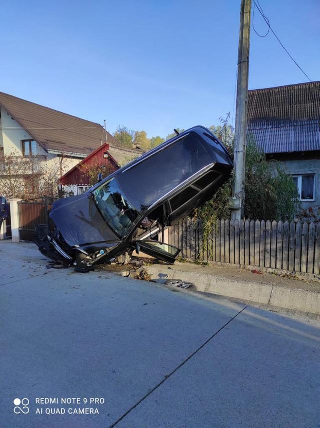 O șoferiță s-a „urcat” cu mașina pe un gard