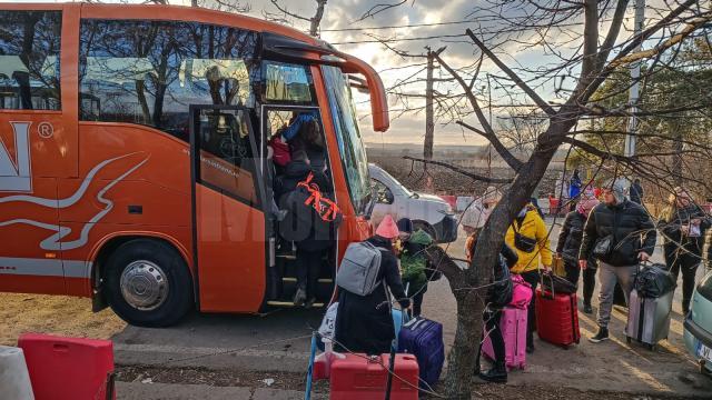 Refugiaţi urcând în autocarul Tarsin