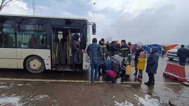 Angajații de la ISU îi ajută pe cei care vin de dincolo de graniță să-și transporte bagajele și copiii