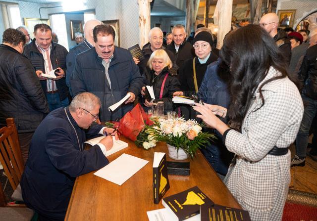 Părintele dr. Viorel Ioan Varlan oferind autografe pe cartea proaspăt lansată