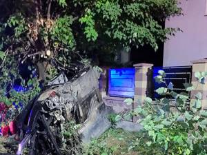 BMW-ul condus de un tânăr a intrat într-un podeț, s-a răsturnat și a ajuns într-un copac