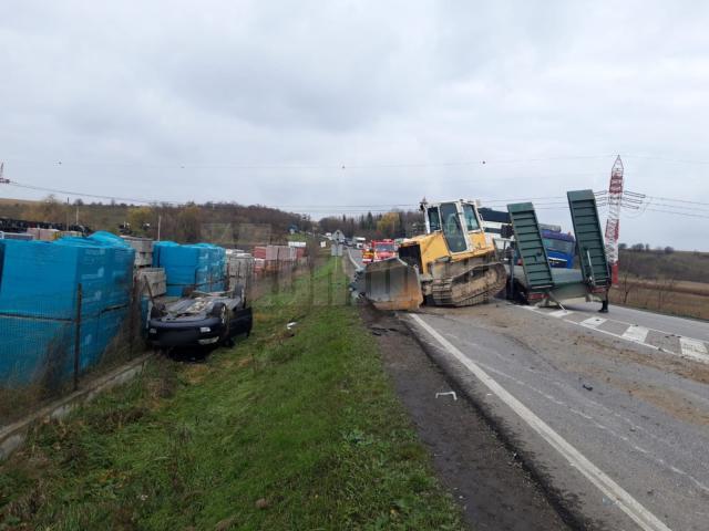 Utilaj căzut de pe o platformă, peste două autoturisme, în trafic