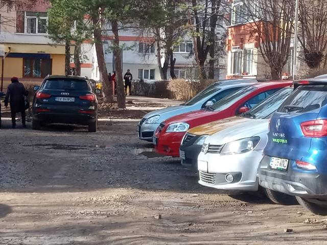 Un teren mocirlit, ocupat de mașini, „spațiul verde” din zona Pieței George Enescu, pentru care s-a luat decizia care permite amenajarea sa ca parcare de reședință